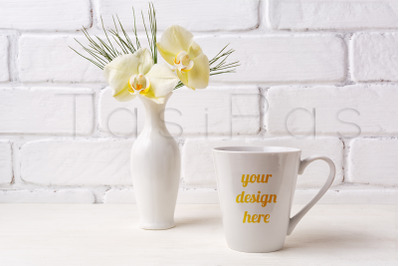 White coffee latte mug mockup with soft yellow orchid in vase.&nbsp;