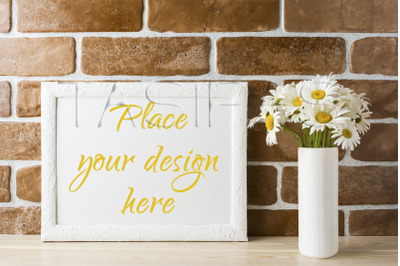 White landscape frame mockup with daisy bouquet in styled vase.
