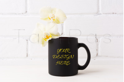 Black coffee mug mockup with soft yellow orchid.