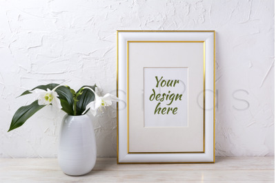 Gold decorated frame mockup with tender white lily in vase.