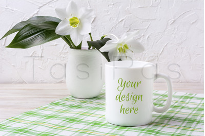 White mug mockup with lily in vase on green checkered napkin