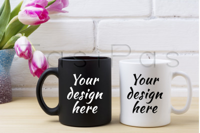 Black coffee mug and white cappuccino cup mockup with pink tulips