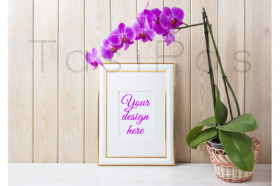 Gold decorated frame mockup with purple orchid in wicker basket