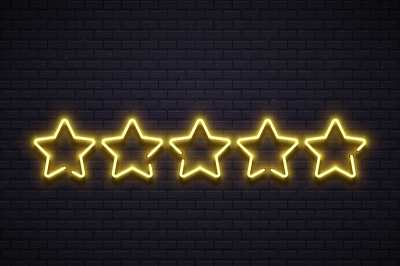 Neon five stars. Golden illuminated star neons lamps on brick wall. Go