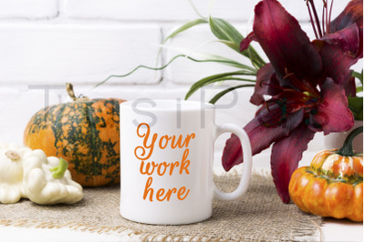 White coffee mug mockup with pumpkin and red lily.