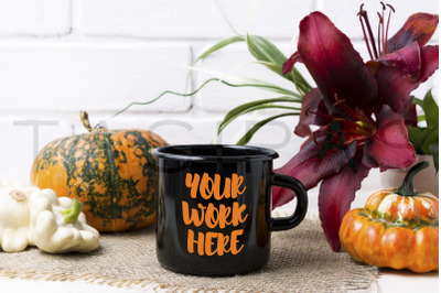 Black campfire enamel mug mockup with pumpkin and red lily.