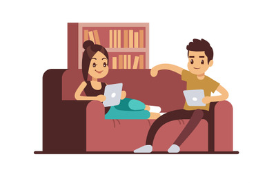 Happy couple on sofa with tablets. Young man and woman relaxing at hom