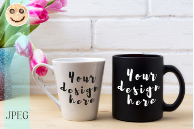 Black coffee cup and white latte mug mockup with magenta tulip