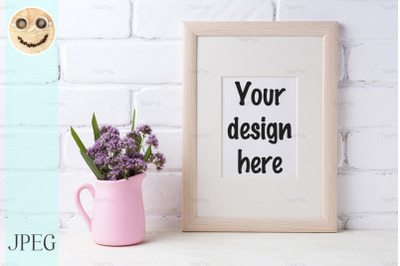 Wooden frame mockup with purple flowers in pink pitcher