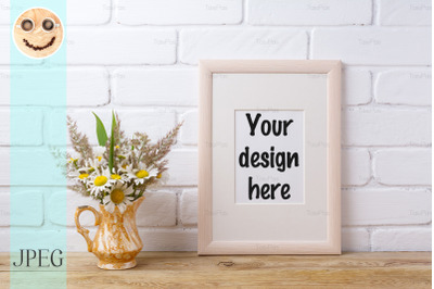 Wooden frame mockup with chamomile and grass in golden pitcher