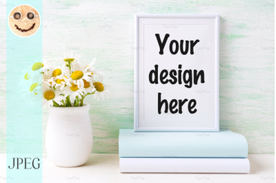 White frame mockup with chamomile bouquet in rustic vase and books