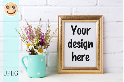 Golden  frame mockup with chamomile and purple flowers in mint green p