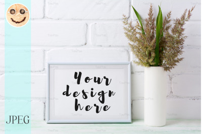 White landscape frame mockup with  grass and green leaves in cylinder