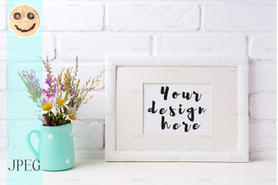 White landscape frame mockup with chamomile and purple flowers in mint