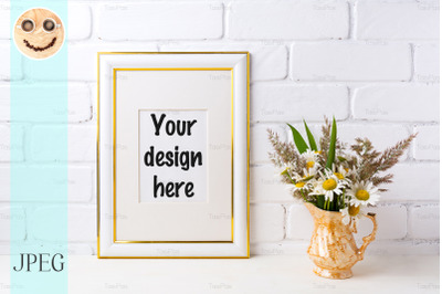 Gold decorated frame mockup with chamomile and grass in golden vase