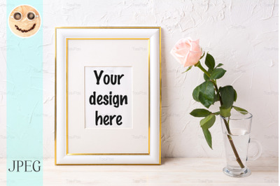 Gold decorated frame mockup with tender pink rose in glass