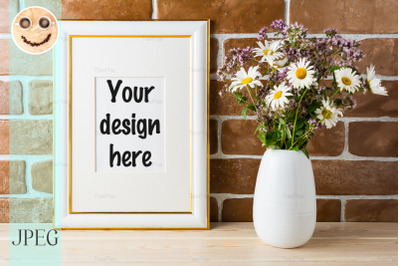 Gold decorated frame mockup with wildflowers bouquet exposed brick wal