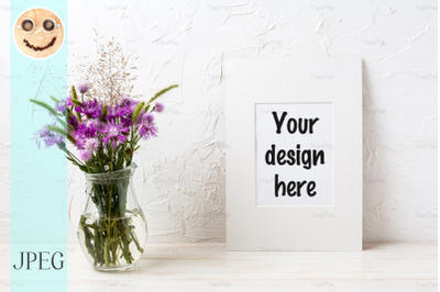 White frame mockup with purple burdock in the glass jug