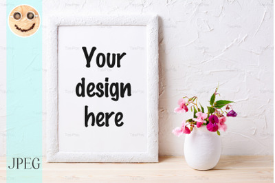 White frame mockup with pink flowers in flowerpot