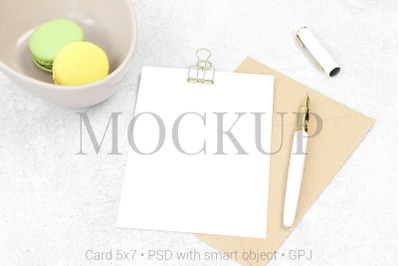Mockup invitation card with pen and macarons