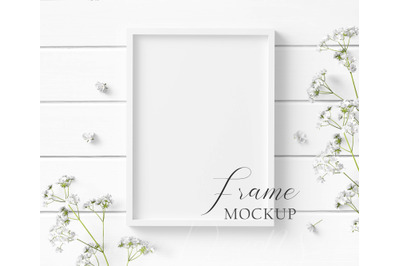 5x7 White Frame Mockup with white flowers on a white wood background.