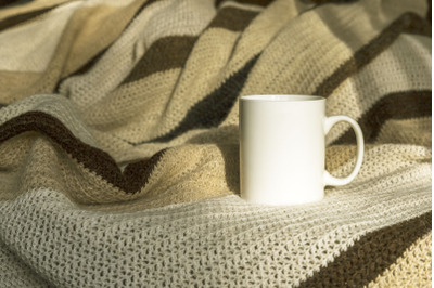 White coffee mug mockup with striped blanket.