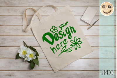 Tote bag mockup with beige notepad.