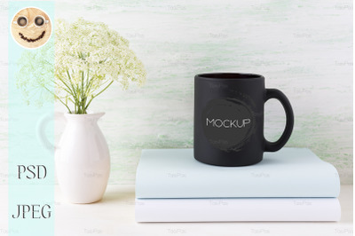 Black coffee mug mockup with books and tender white flowers.