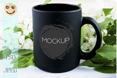 Black coffee mug mockup with apple blossom.