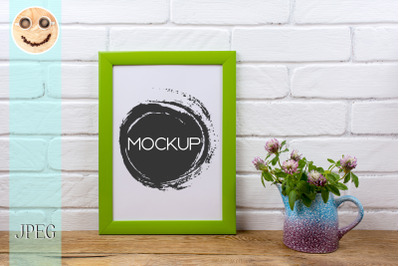 Green poster frame mockup with pink clover in pitcher