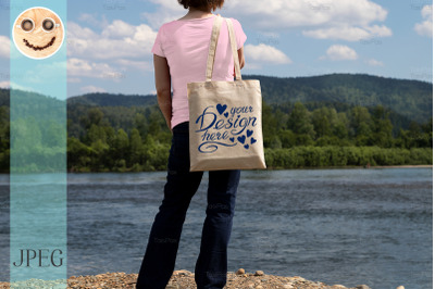 Woman in pink tee holding tote bag mockup