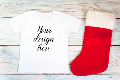 Kids Christmas White T-shirt mockup on a wooden background.