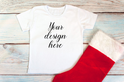 Kids Christmas White T-shirt mockup on a wooden background.