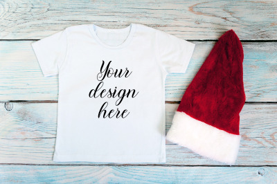 Kids Christmas White T-shirt mockup on a wooden background.