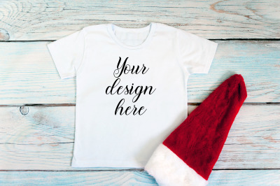 Kids Christmas White T-shirt mockup on a wooden background.