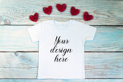 Valentines Day kids t-shirt mockup on a wooden background.