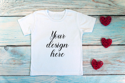 Valentines Day kids t-shirt mockup on a wooden background.