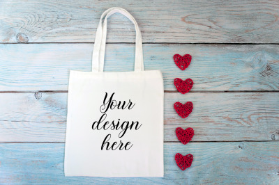 Valentines Day white tote bag mockup on a wooden background.
