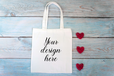Valentines Day white tote bag mockup on a wooden background.