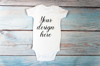 Baby Bodysuit mockup with toy on a wooden background.