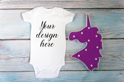 Baby Bodysuit mockup with toy on a wooden background.