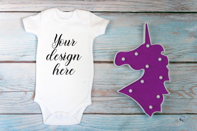 Baby Bodysuit mockup with toy on a wooden background.