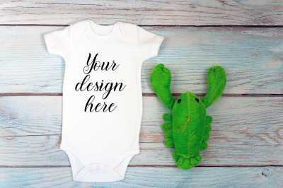 Baby Bodysuit mockup with toy on a wooden background.