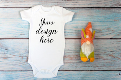 Baby Bodysuit mockup with toy on a wooden background.