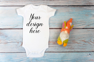 Baby Bodysuit mockup with toy on a wooden background.