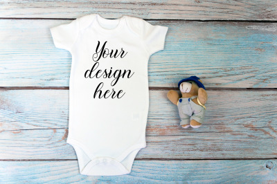 Baby Bodysuit mockup with toy on a wooden background.