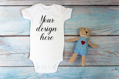 Baby Bodysuit mockup with toy on a wooden background.