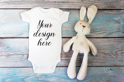 Baby Bodysuit mockup with toy on a wooden background.