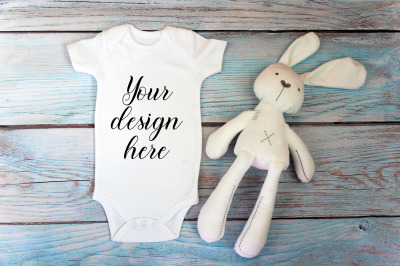 Baby Bodysuit mockup with toy on a wooden background.