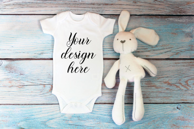 Baby Bodysuit mockup with toy on a wooden background.